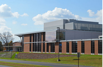 An image of a building with windows and a grassy field. Penn State Harrisburg Educational Activities Building